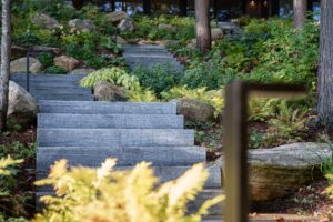 Stone pathway and native landscape leading to a custom Alderstone Homes build in Ontario, designed to blend naturally with the surrounding environment.