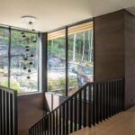 Stairwell with floor-to-ceiling glass and natural light designed by Alderstone Homes at Cottage in Muskoka.