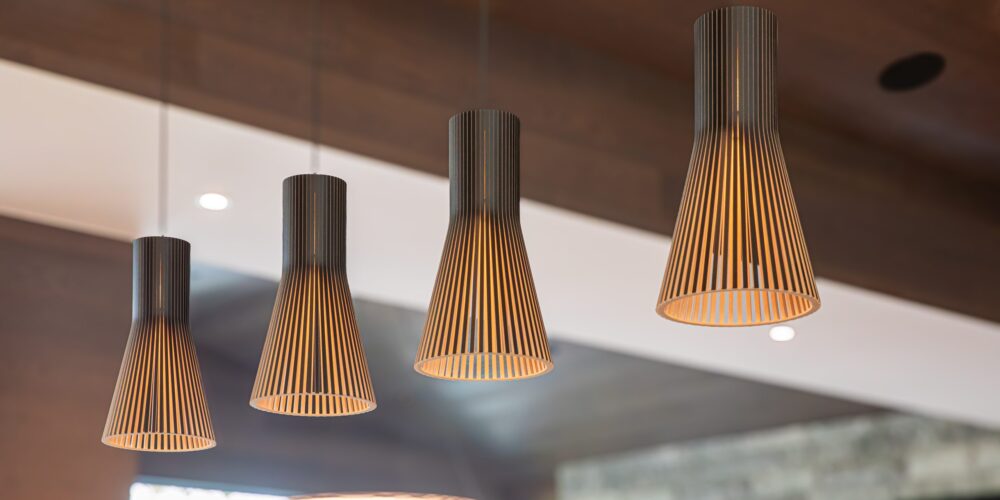 Contemporary pendant lighting with warm wood slats and soft glow, designed for Alderstone Homes’ project in Muskoka.