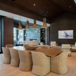 Warm modern cottage interior with natural wood finishes, stone fireplace, and lake views designed by Alderstone Homes in Muskoka.